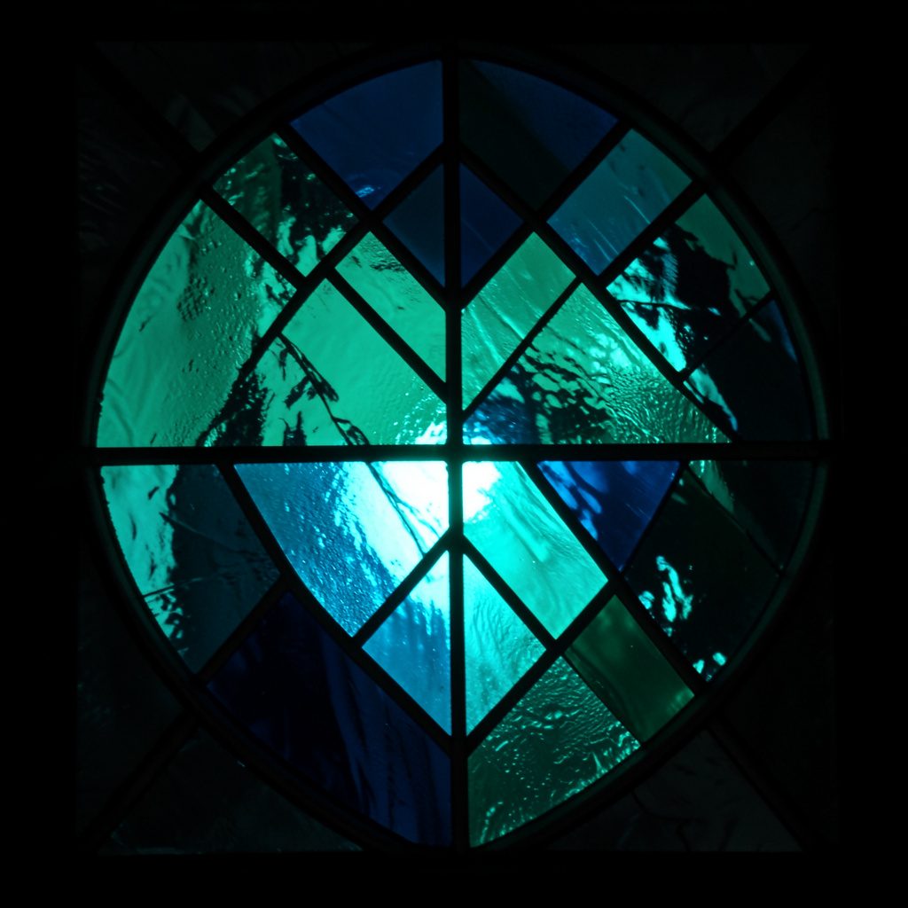 Stained glass composition with bold leaded segments in teal, rose pink and amber, soft and luminous mood