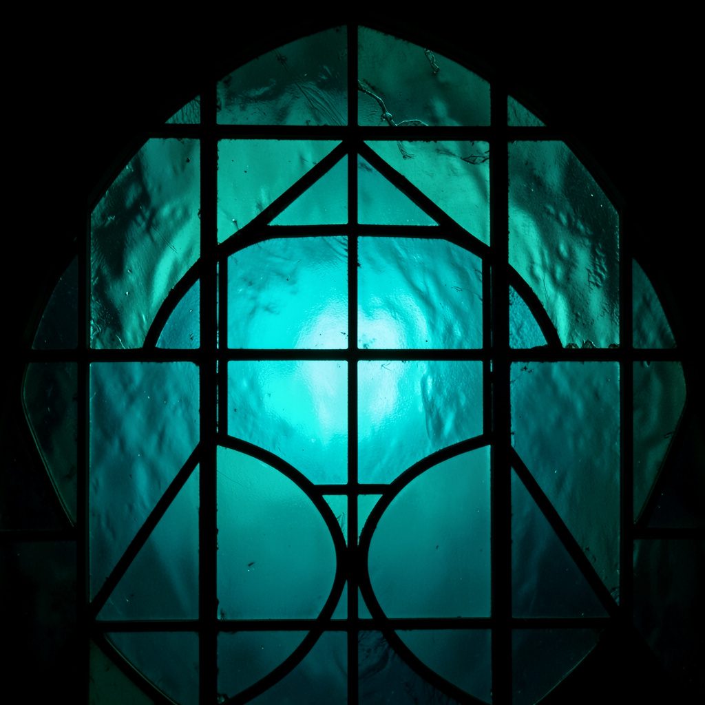 Stained glass composition with bold leaded segments in teal, rose pink and amber, soft and luminous mood